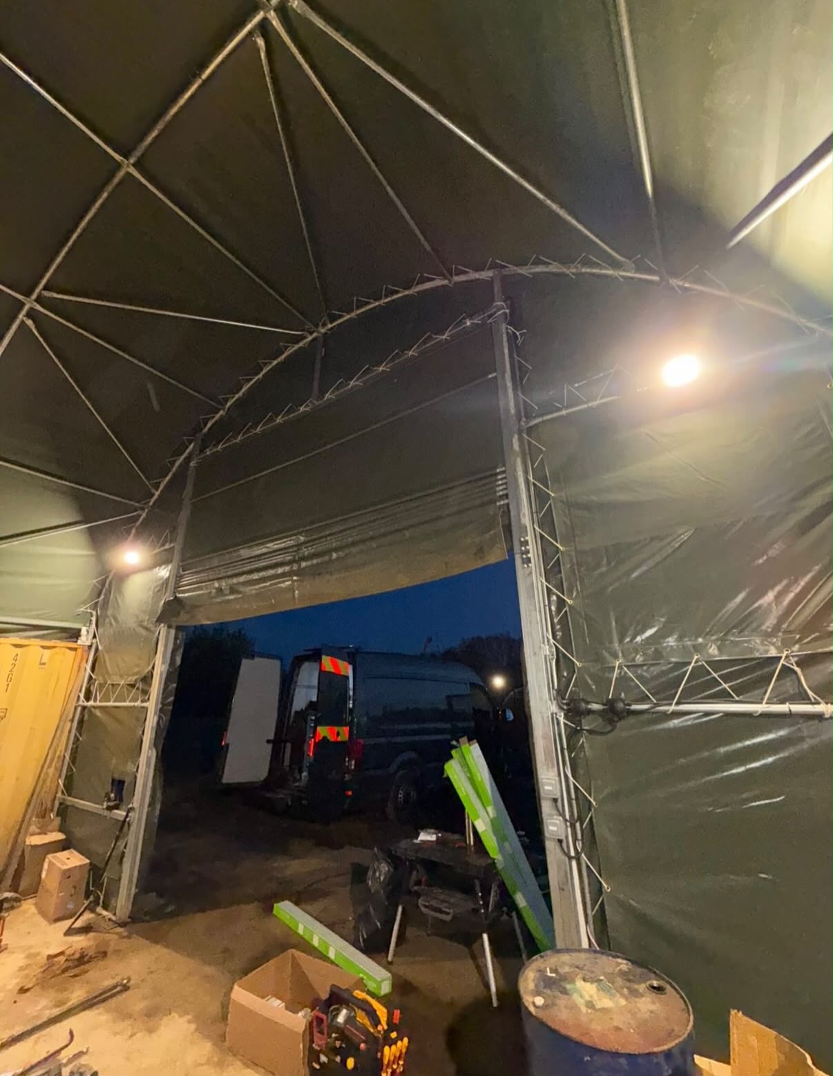 Canopy lighting switched on at dusk with a Northants Electrical Co van parked beyond the opening