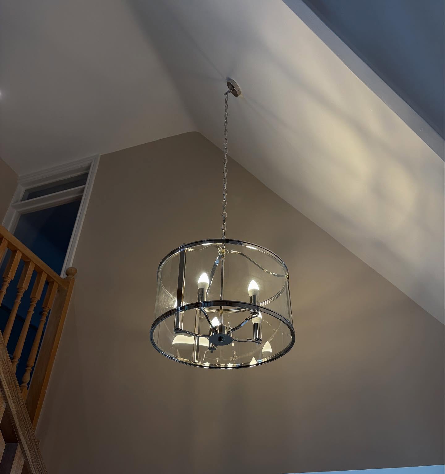 Chrome drum pendant installed on a chain in a double height stairwell