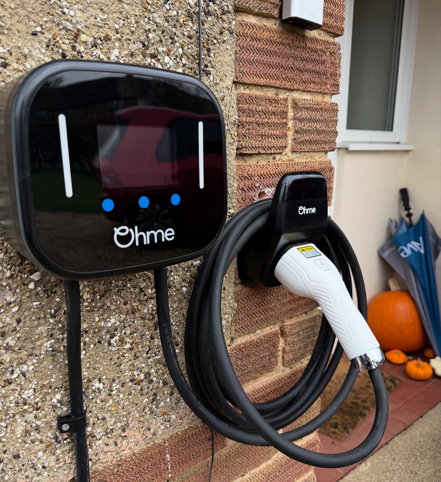Electric vehicle charger with coiled lead installed on a domestic wall in Northampton