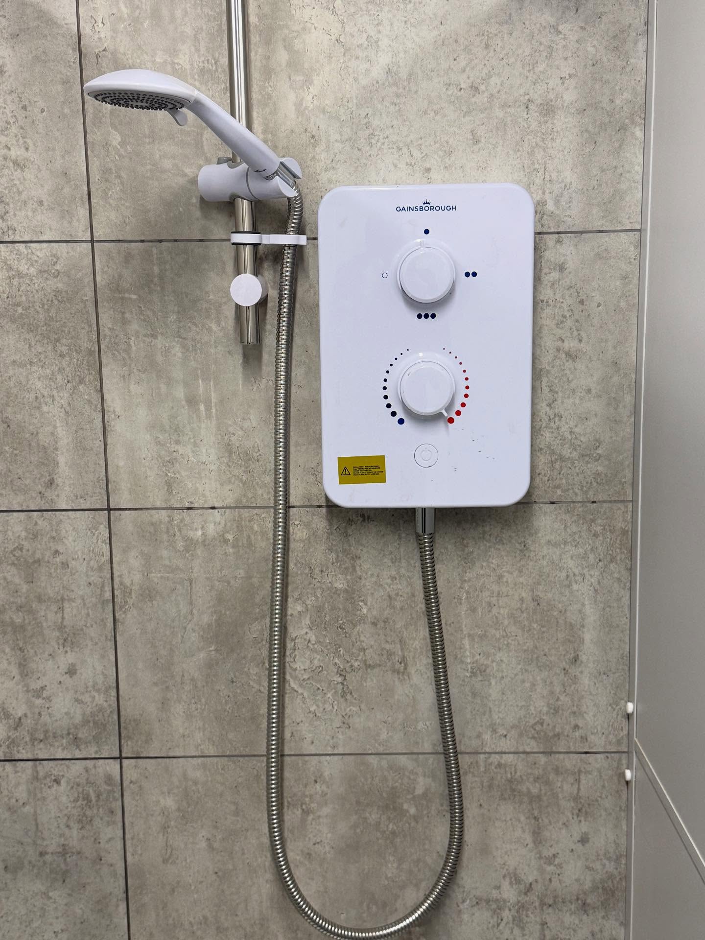 Electric shower supply installed on a tiled wall